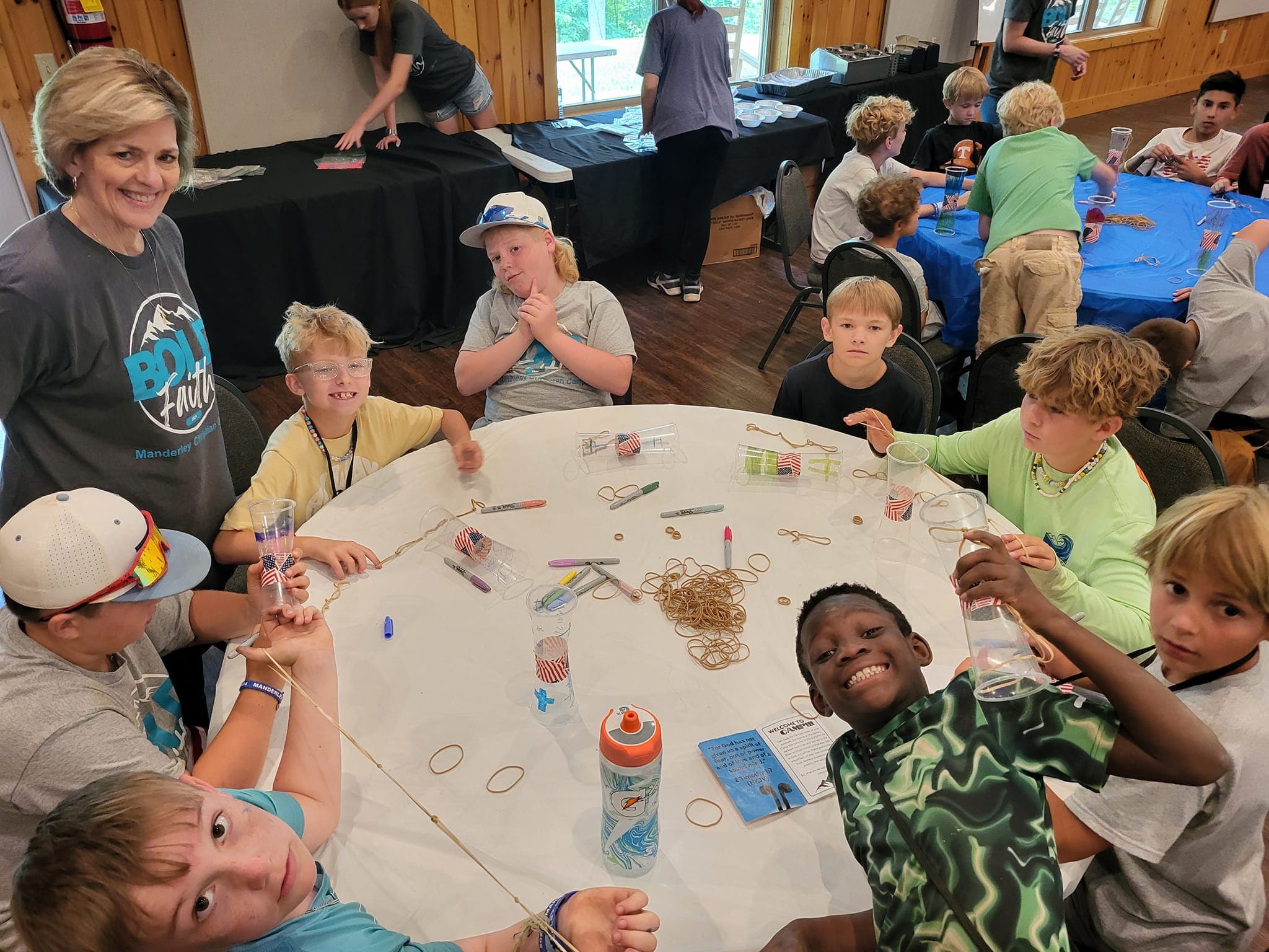 Kids doing crafts around a table at camp