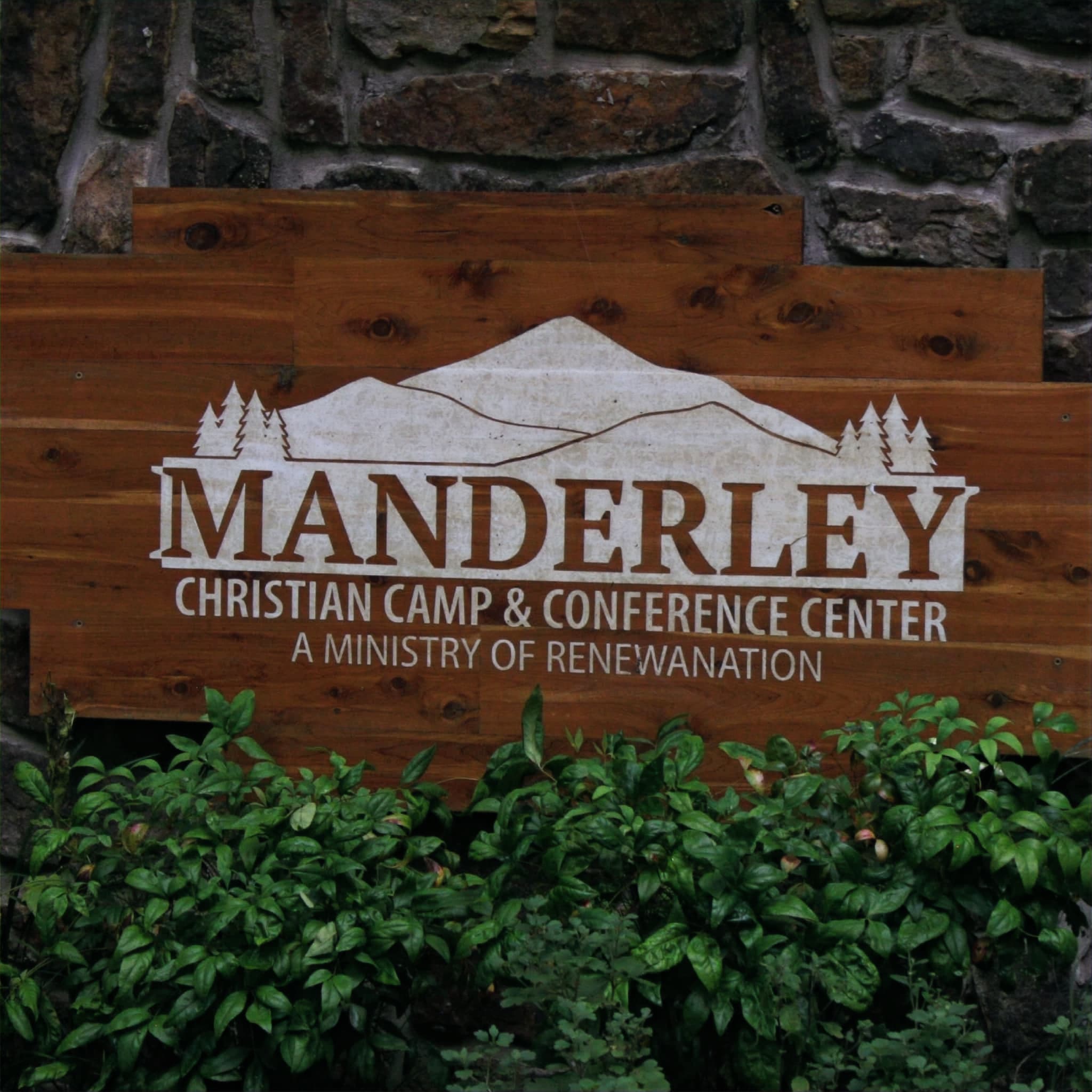 Manderley Christian Camp & Conference Center wooden sign on a stone wall