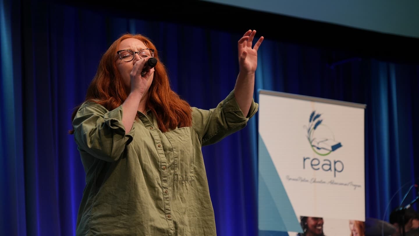 Worship leader singing at a REAP event