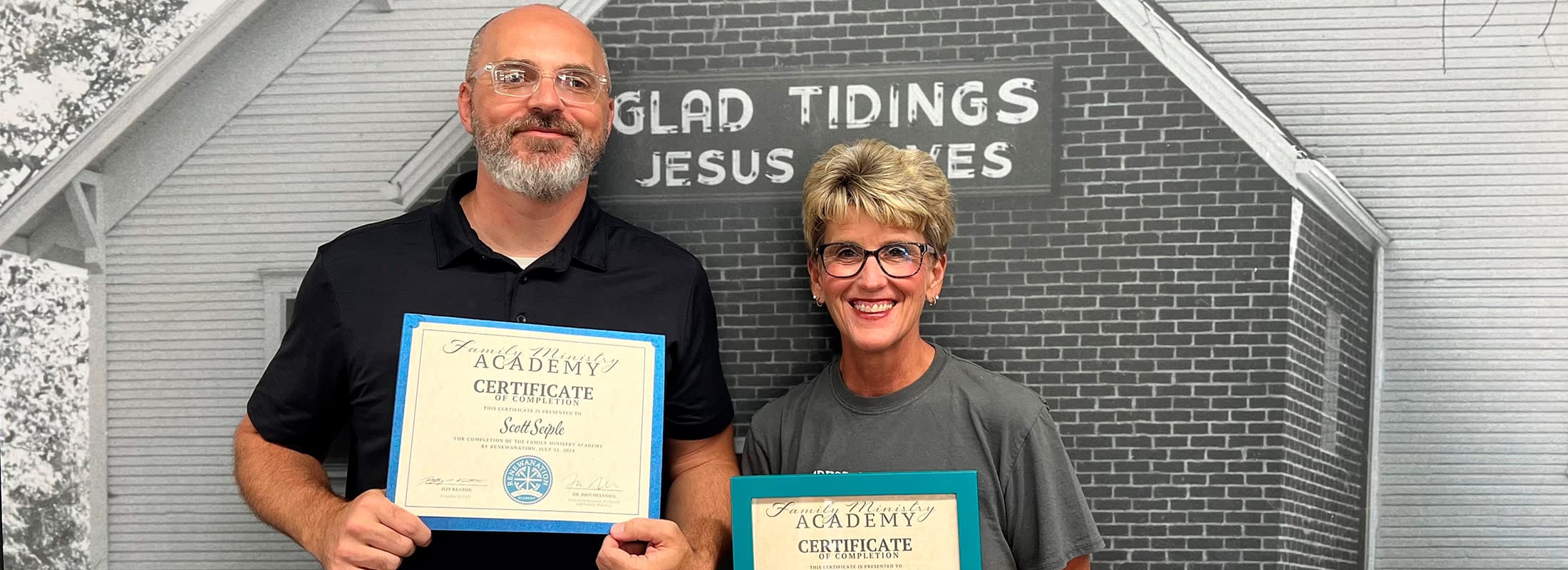 Couple holding Family Ministry Academy certificates outside their church