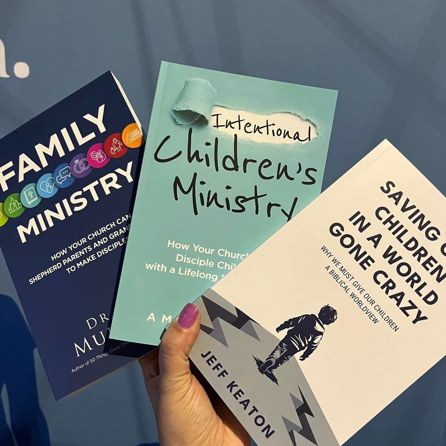 Hand holding Family Ministry, Intentional Children's Ministry, and Saving Our Children books