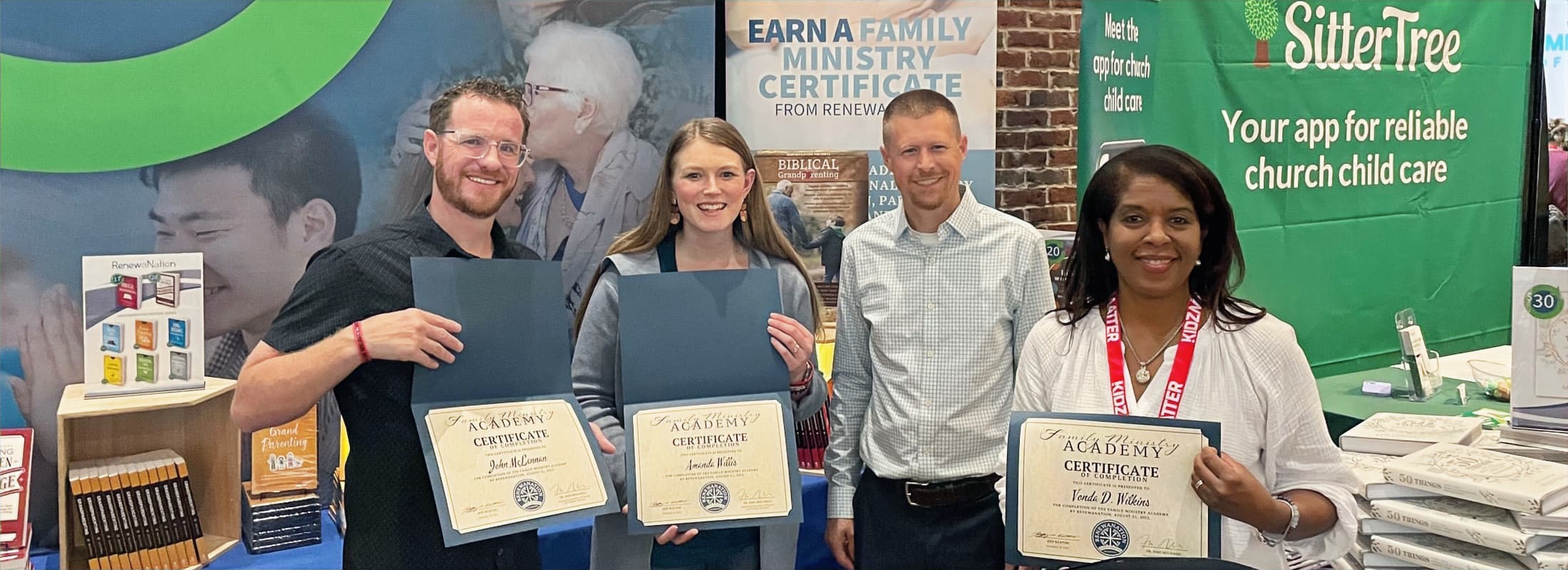 Family ministry certificate recipients at an exhibit booth