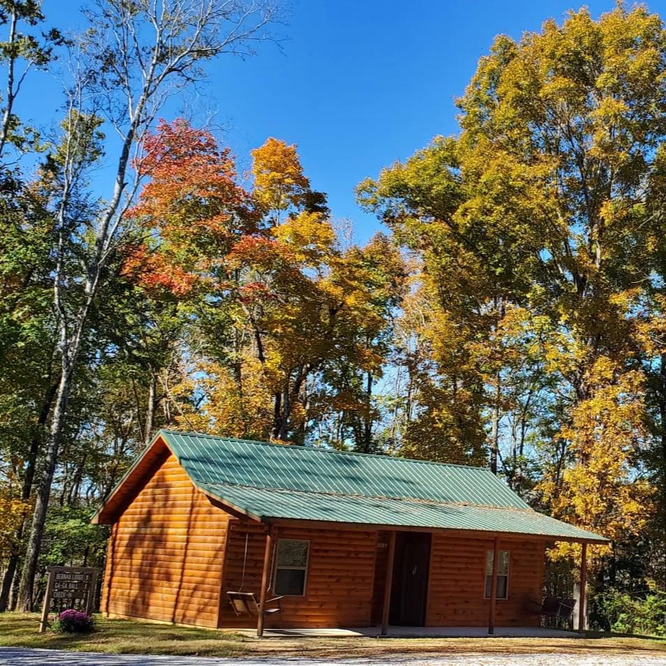 Log cabin with green metal roof at Manderley Christian Camp in autumn