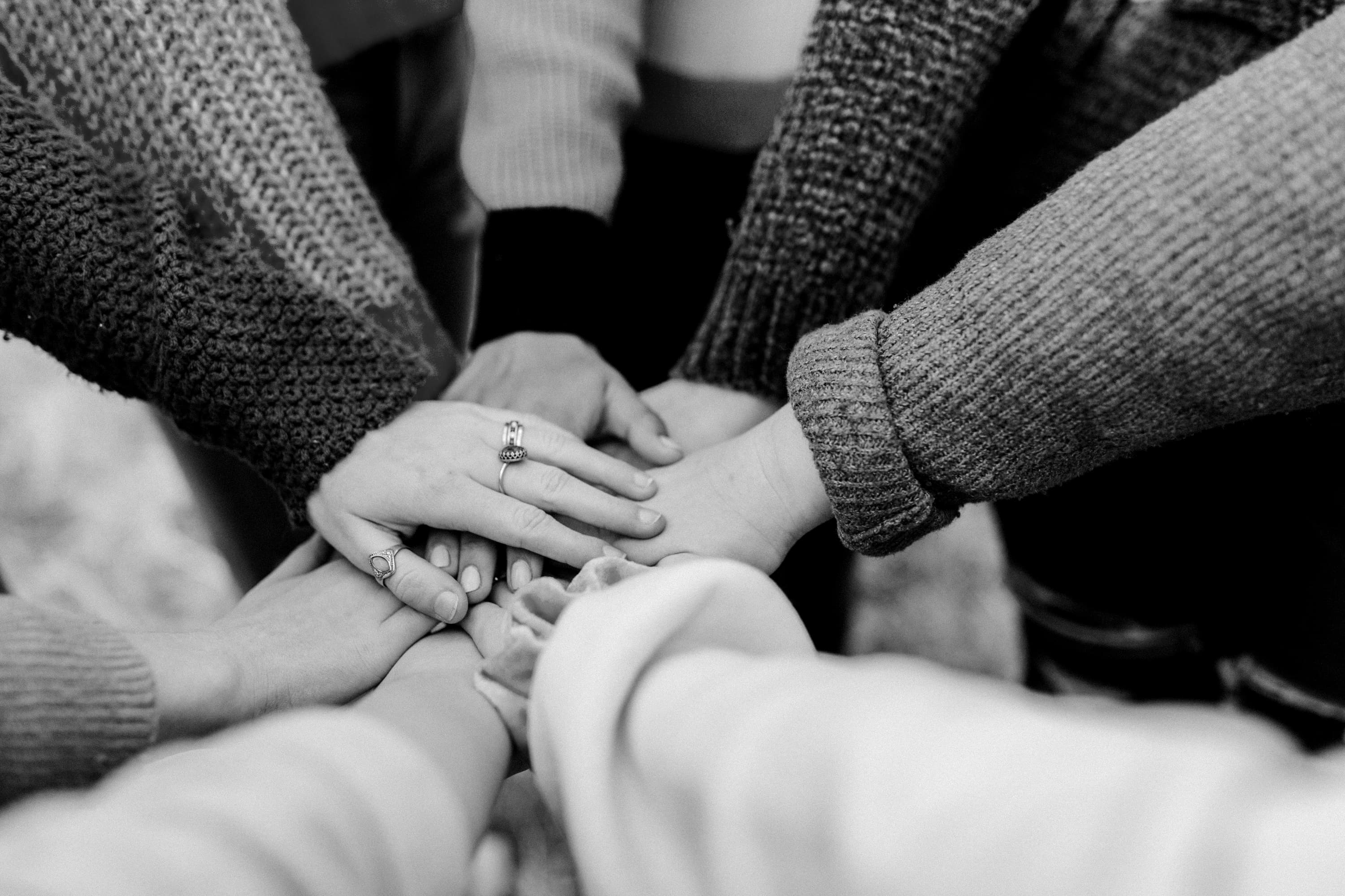 Friends stacking hands together in partnership