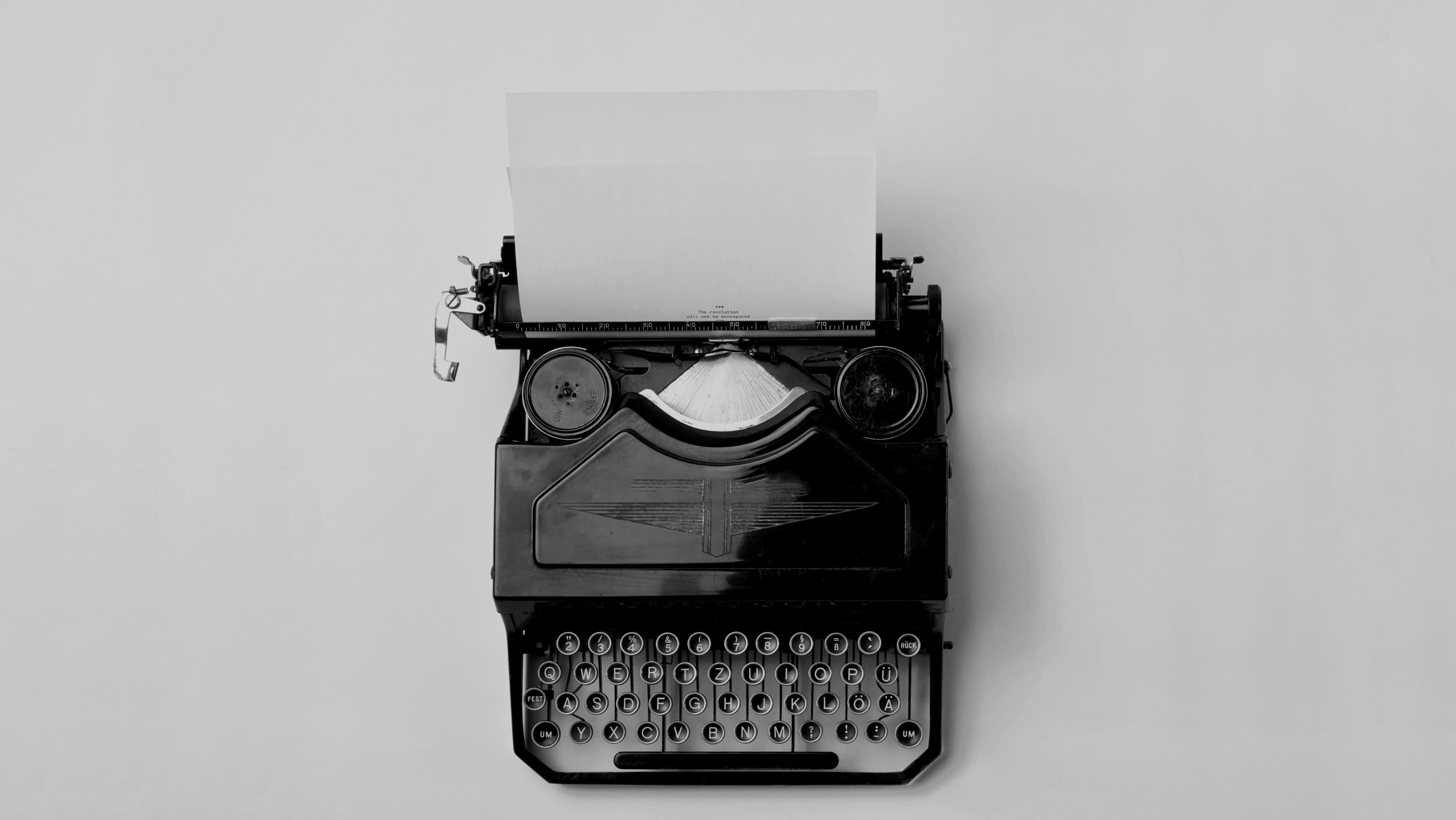 Vintage typewriter with a blank sheet of paper, in black and white